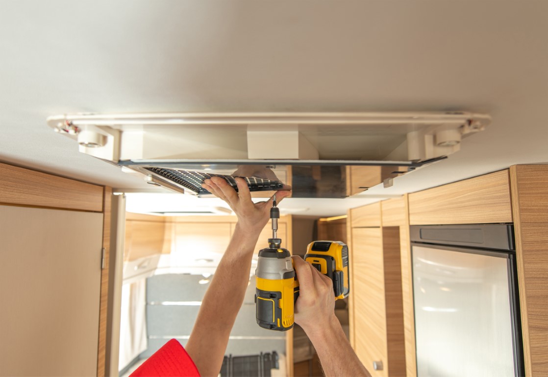 RV Technician Worker Replacing Air Conditioner Unit Inside Motor